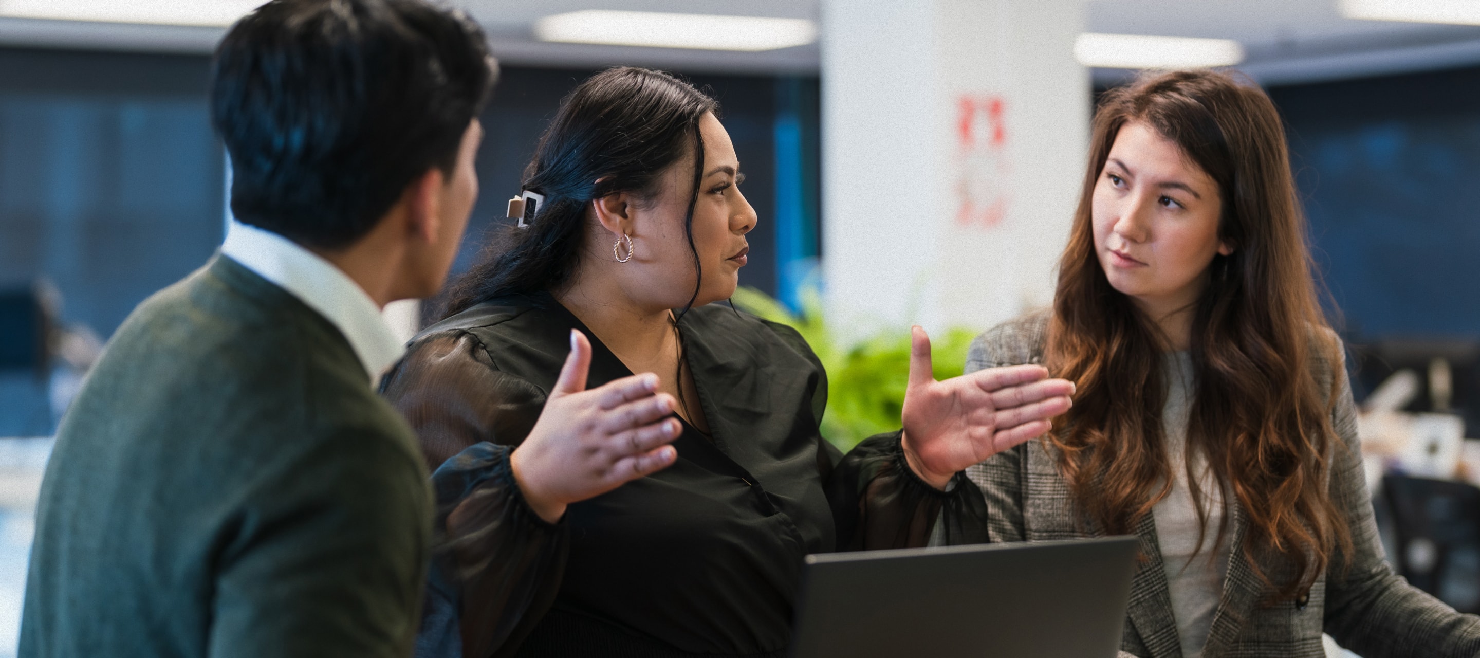 A woman expressing an idea to the group in an office space.